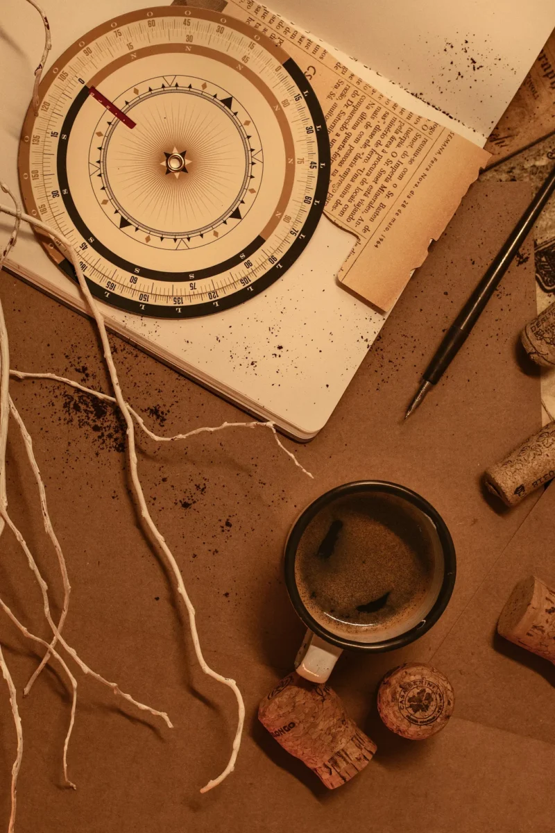 Notebook, coffee and dried roots arranged on warm brown paper
