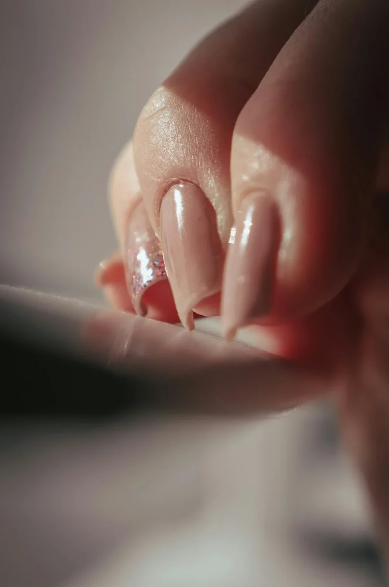 Long nude nails with a fine shimmer, photographed close up